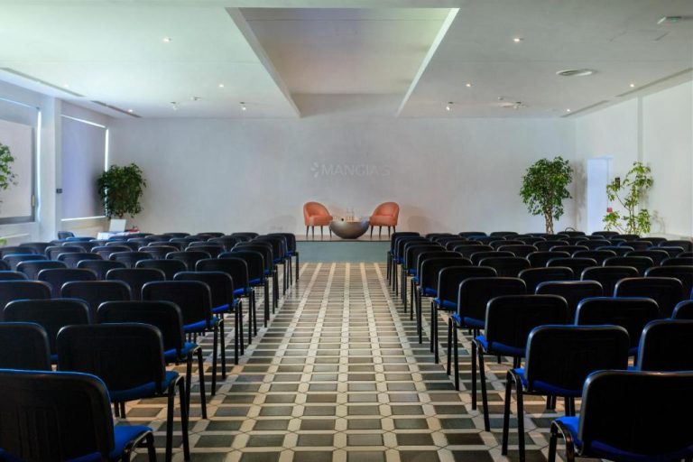 Sala de conferencias con sillas y escenario del Mangia's Torre Del Barone Resort & SPA