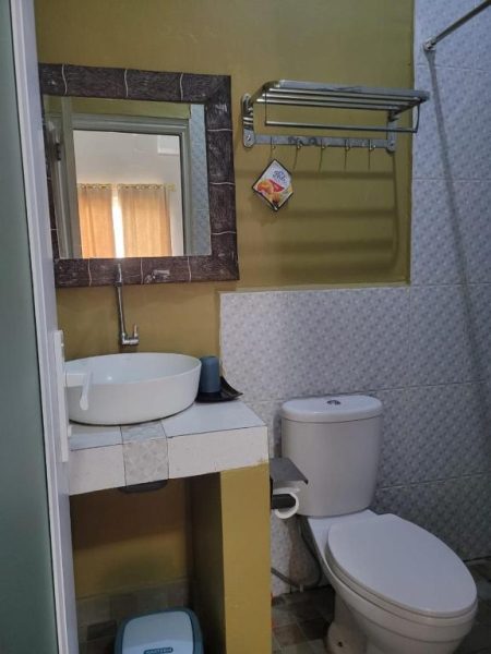 Baño privado con lavabo, espejo y sanitario en 9 Residences Seminyak, Bali