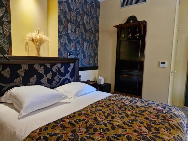 Habitación doble del Château de Saulon con cabecero azul floral y elegante armario de madera oscura
