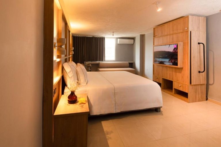Habitación doble moderna con cama king, televisor empotrado y decoración en madera del Mood Matuna Hotel Cartagena