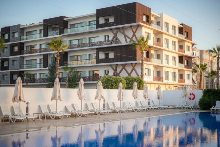 Piscina exterior con tumbonas y sombrillas del Hotel Zephyr Agadir frente al edificio principal