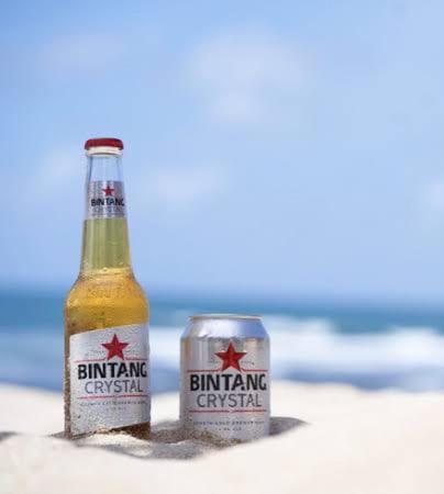 Cerveza Bintang Crystal en botella y lata sobre la arena de la playa en 9 Residences Seminyak Bali