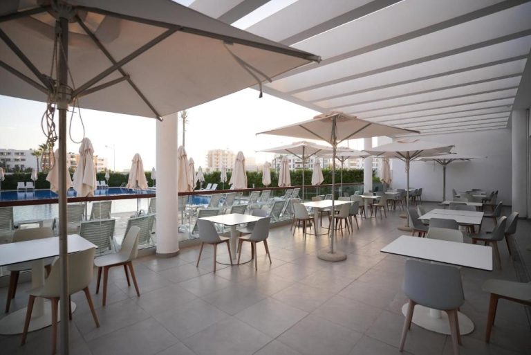 Terraza restaurante con mesas blancas y sombrillas del Hotel Zephyr Agadir con vistas a la piscina