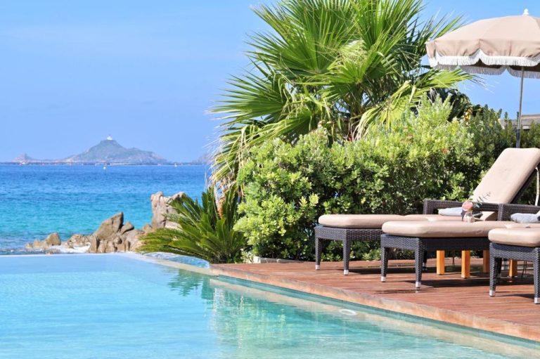 Piscina infinita con tumbonas y vistas al mar turquesa del Hôtel Le Week End en Córcega