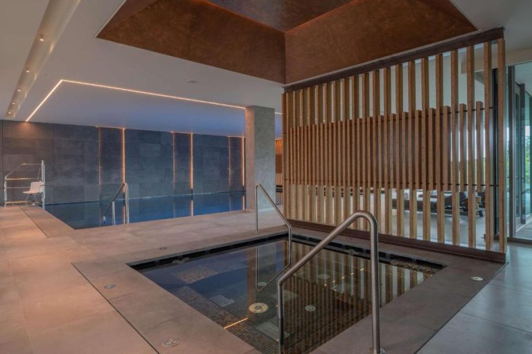 Piscina interior y jacuzzi del spa en el Doubletree by Hilton Lagoa Azores con iluminación ambiental