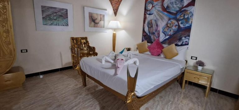 Habitación de lujo con decoración egipcia y cama dorada en el hotel Aton Palace Luxor