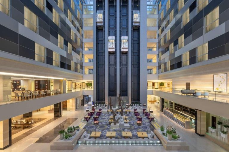 Amplio atrio interior del Hyatt Regency Oryx Doha con zona lounge, restaurantes y ascensores panorámicos