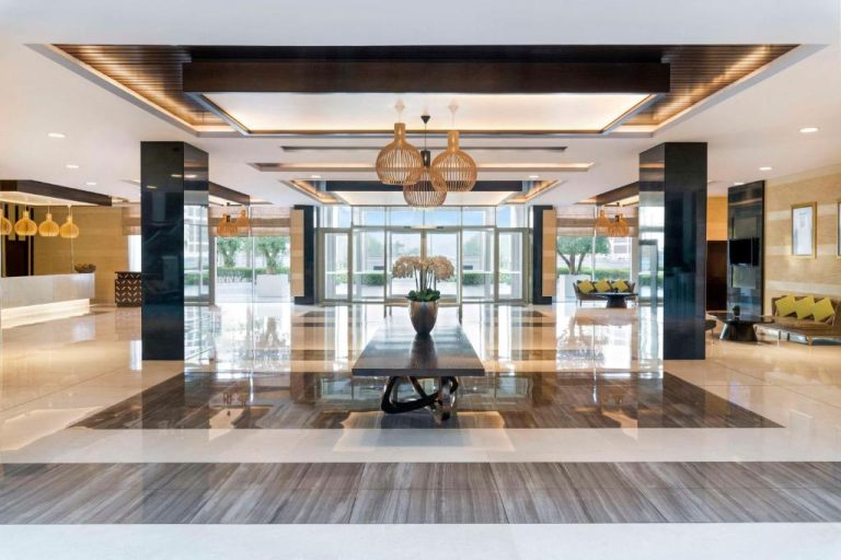 Lujoso lobby del Hyatt Regency Oryx Doha con suelos de mármol, columnas negras y decoración elegante