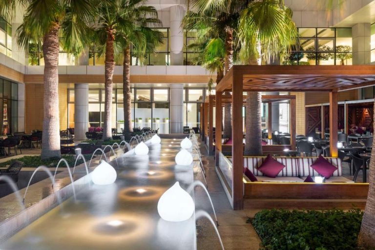Terraza exterior con fuentes luminosas y cabañas lounge del Hyatt Regency Oryx Doha