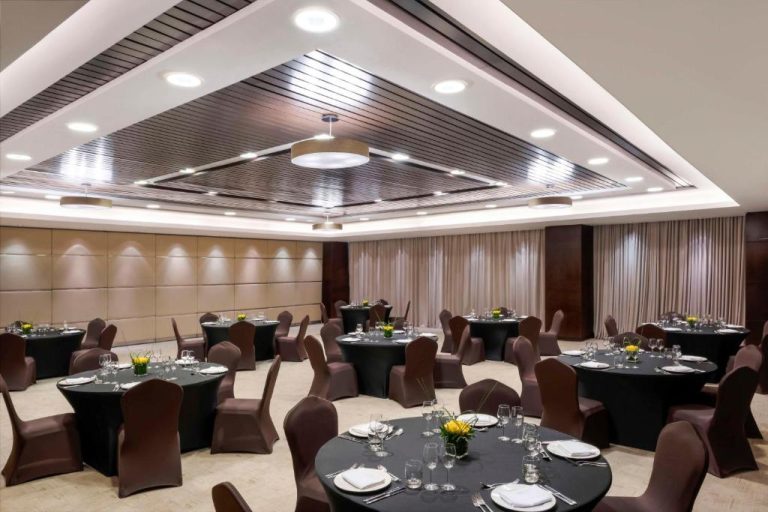 Salón de banquetes elegante con mesas redondas y sillas en el Hyatt Regency Oryx Doha