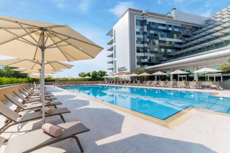 Piscina exterior con tumbonas y sombrillas del Hyatt Regency Oryx Doha en Qatar