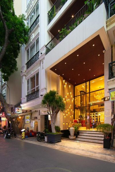 Fachada e entrada iluminada del Le Premier Hotel & Rooftop Bar con decoración moderna en Vietnam