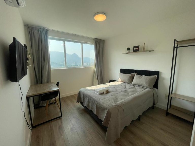 Habitación moderna con cama doble y vista a las montañas en Loft Barra da Tijuca Ilha Pura