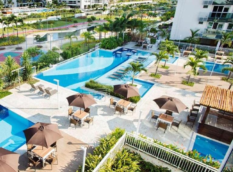 Piscina exterior con sombrillas y tumbonas del Loft Barra da Tijuca Ilha Pura en Río de Janeiro