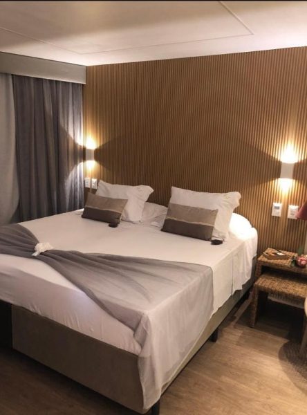Habitación doble con cama king size y pared de madera en Hotel Fortaleza 703-713