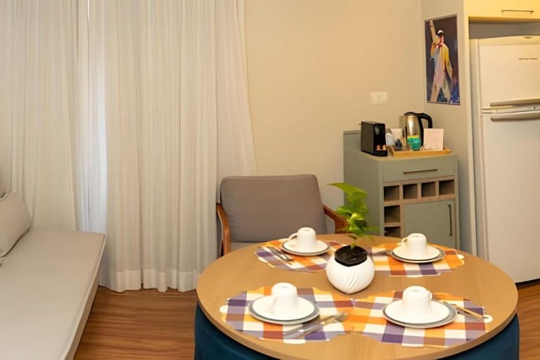 Comedor con mesa redonda y cocina equipada del Lindo Flat na Sena Madureira, apartamento acogedor