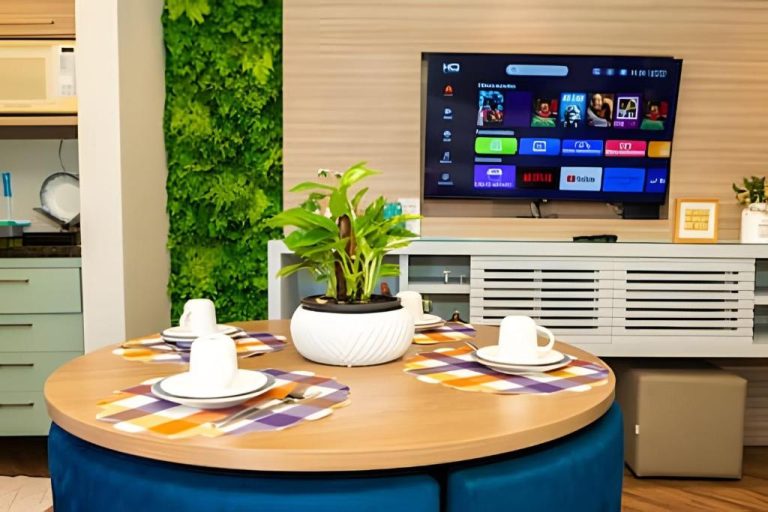 Sala comedor con mesa redonda, planta verde y smart TV del apartamento Lindo Flat na Sena Madureira