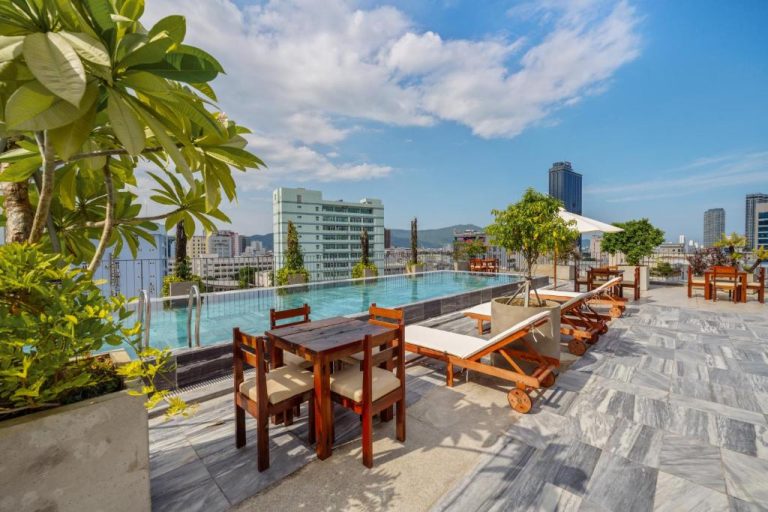 Piscina infinita en la azotea del Vernal Hotel & Apartment Da Nang con tumbonas y vistas a la ciudad