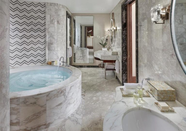 Lujoso baño de mármol con jacuzzi redondo y doble lavabo en Mandarin Oriental Doha