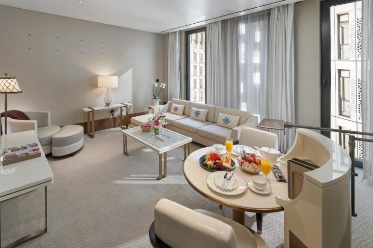 Elegante suite con salón y mesa de comedor del Mandarin Oriental Doha con decoración de lujo