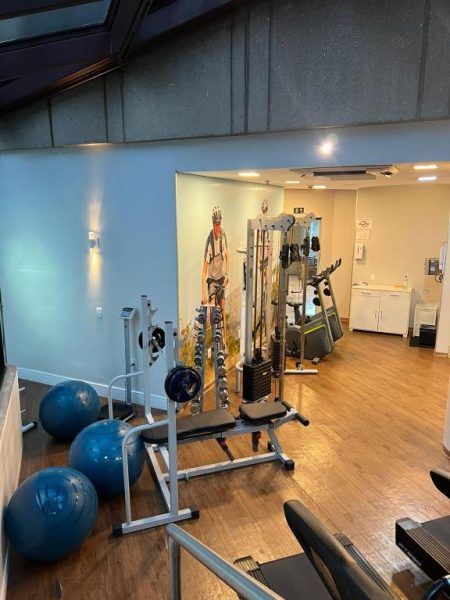 Gimnasio completamente equipado con máquinas de pesas y pelotas fitness en Lindo Flat Moema