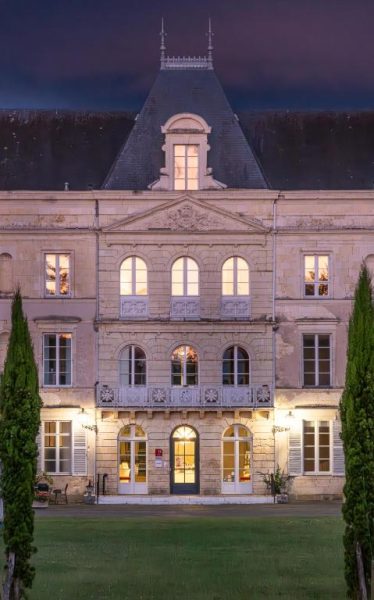 Fachada iluminada al atardecer del Château de Briançon The Originals Relais con jardín