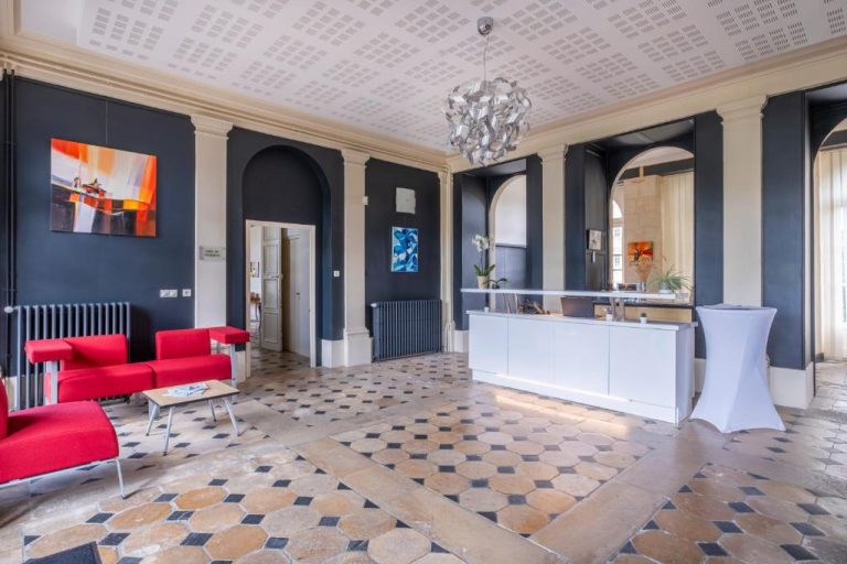 Recepción y lobby elegante del Château de Briançon The Originals Relais con suelo de piedra y decoración clásica