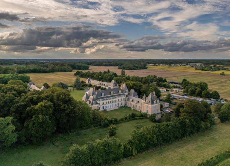 Vista aérea del Château de Briançon The Originals Relais rodeado de jardines y campos verdes en Francia