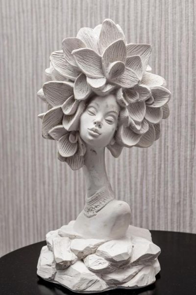 Escultura decorativa de busto femenino con flores en el Hotel Hola Medellín