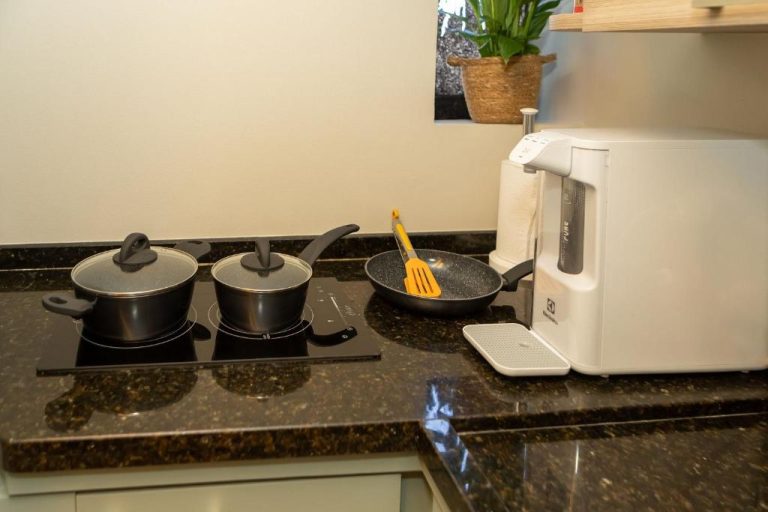 Cocina equipada con vitrocerámica, ollas y cafetera del apartamento Lindo Flat na Sena Madureira
