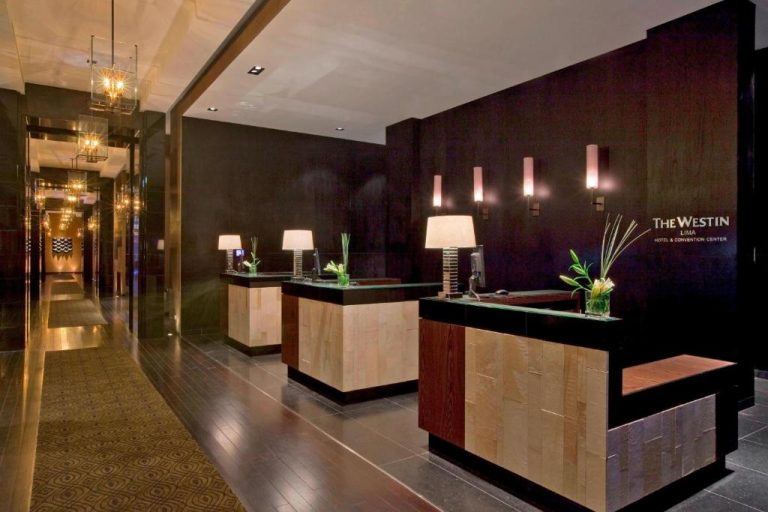 Recepción moderna con mostradores de madera y lámparas elegantes en The Westin Lima Hotel & Convention Center