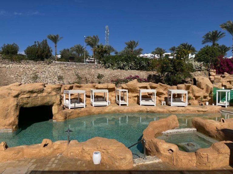 Piscina natural entre rocas con tumbonas de lujo en Elisir SPA & Hotel en la costa de Sheikh