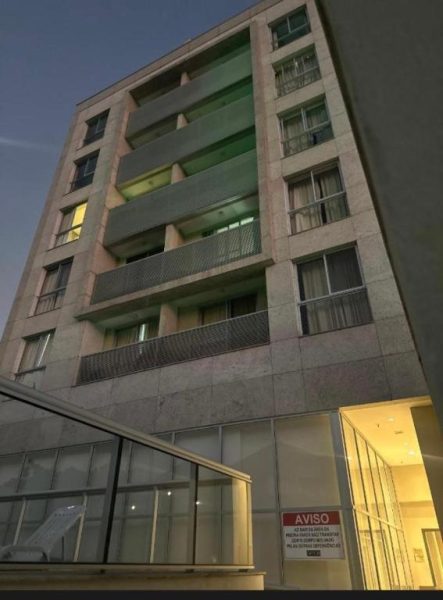 Fachada exterior del Suite Incrível Sonhos e Praia al atardecer con balcones y entrada iluminada