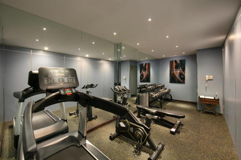 Gimnasio moderno con cintas de correr y bicicletas estáticas del Anatole Hotel Hanoi