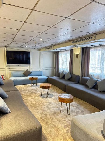 Amplio salón lounge con sofás y televisión del crucero por el Nilo Coral 2 entre Luxor y Asuán