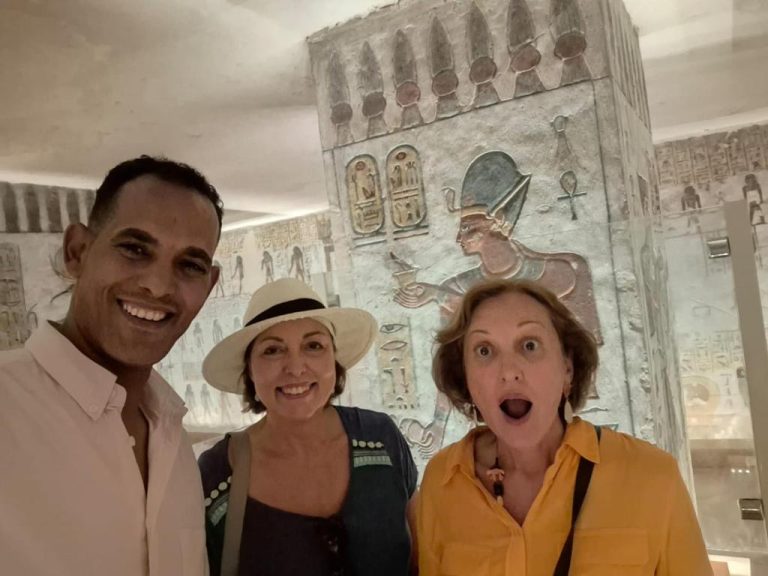 Turistas posando junto a relieves jeroglíficos egipcios en excursión del Aton Palace Luxor