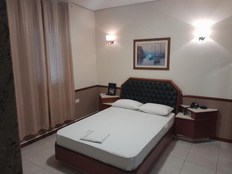 Habitación doble con cama matrimonial y cabecero acolchado negro en Hotel Paris