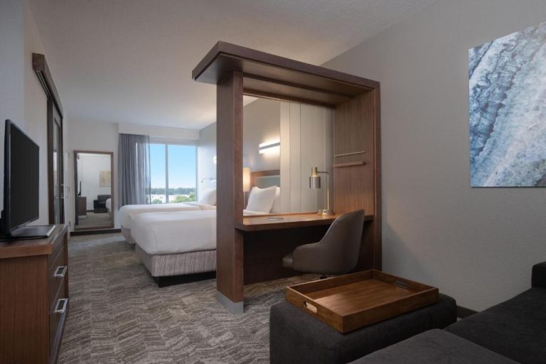 Suite con área de trabajo y dormitorio separado en SpringHill Suites by Marriott Orlando Flamingo Crossings
