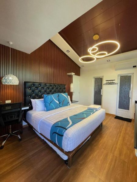 Habitación doble de lujo con cama king size y cabecero capitoné negro en Italy Condotel Darasa