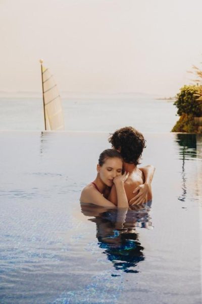 Pareja romántica abrazada en la piscina infinita con vistas al mar del hotel La Badira Adult Only
