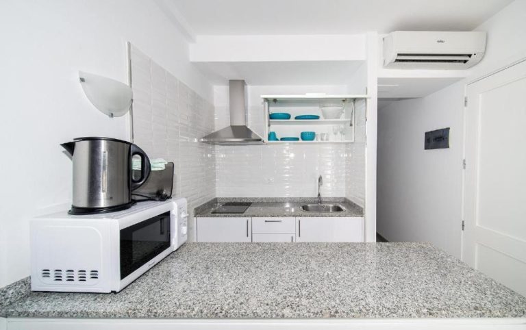 Cocina equipada con microondas, hervidor y zona de lavado en Apartamentos Monte Verde