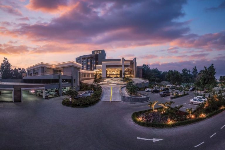 Fachada exterior del Glee Hotel Nairobi iluminada al atardecer con aparcamiento y jardines tropicales