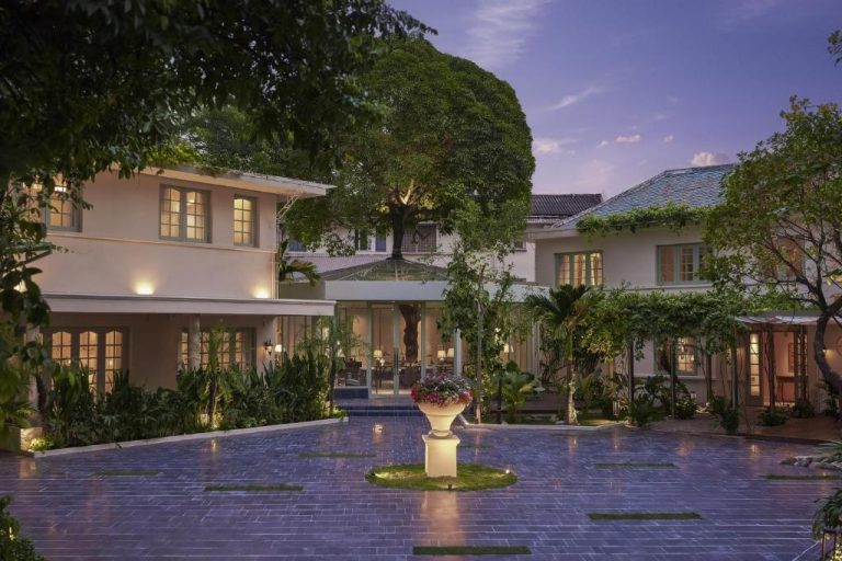Jardín exterior iluminado con fuente central del President Maison Signature en ambiente nocturno