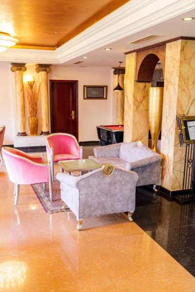 Salón lobby del Cesar Palace Sousse con sofás, sillas rosas y mesa de billar al fondo