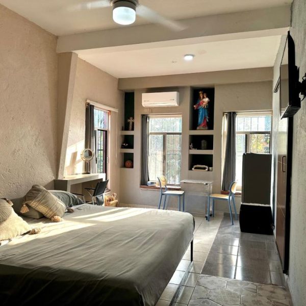 Habitación doble luminosa con cama matrimonial, aire acondicionado y TV en Habitaciones Dos Antonios