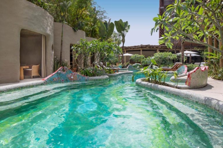 Piscina de aguas cristalinas rodeada de vegetación tropical en el Rosewood São Paulo