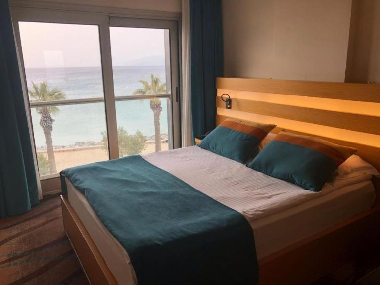 Habitación doble con cama matrimonial y vistas al mar turquesa en Hotel Ilayda