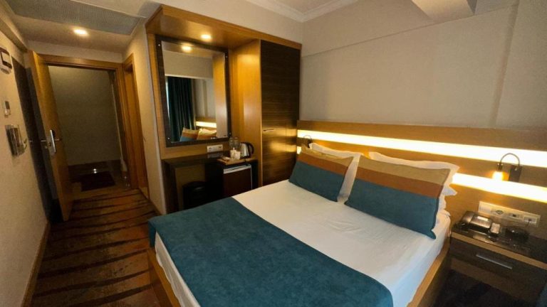 Habitación doble con cama matrimonial y cabecero iluminado en Hotel Ilayda