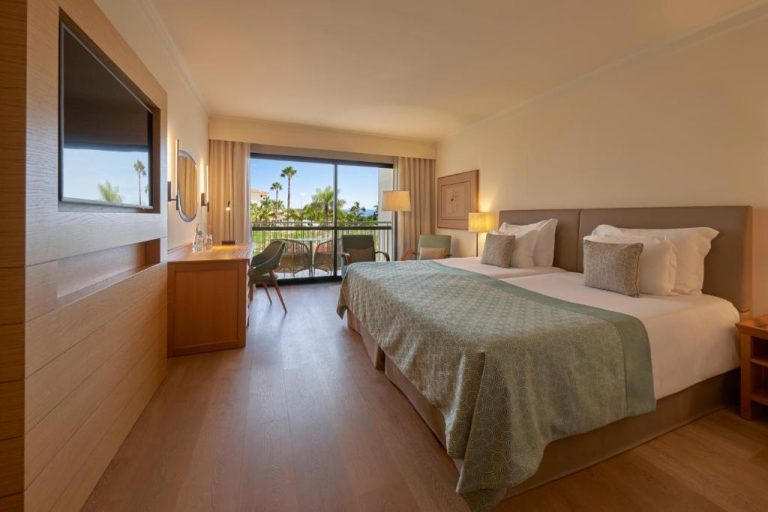 Habitación doble con balcón y vistas a palmeras en Hotel Porto Mare PortoBay Madeira