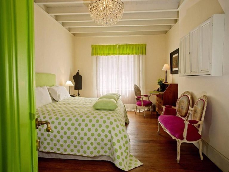 Habitación doble con decoración verde y araña de cristal en Quinta Miraflores Boutique Hotel